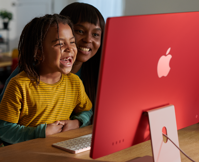 Pessoas de uma família riem juntas enquanto assistem a uma série no iMac.
