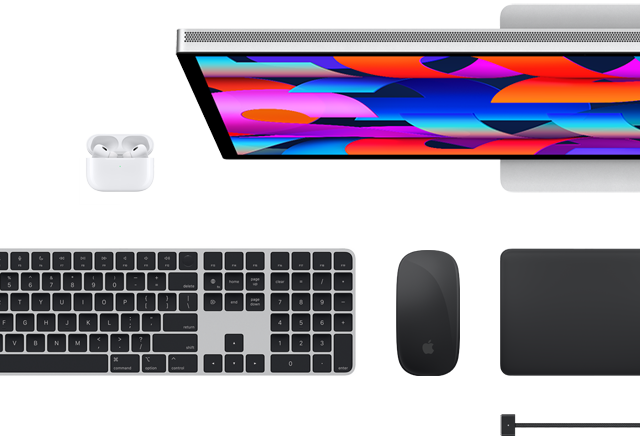 Imagem de cima de acessórios para Mac: Studio Display, Magic Keyboard, Magic Mouse, Magic Trackpad, AirPods e cabo MagSafe para recarga